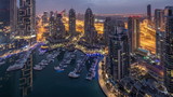 Fototapeta Londyn - Aerial top view of Dubai Marina night to day timelapse. Modern towers and traffic on the road