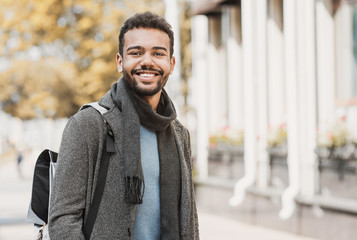 handsome joyful man autumn portrait. smiling men student wearing warm clothes in a city in winter