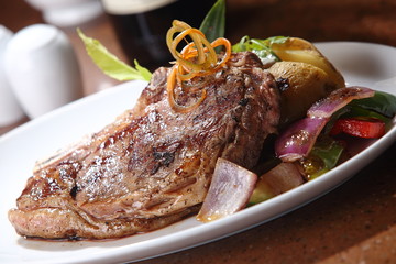 T-bone steak grilled beef with red and green peppers and baked potato.