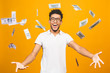 © denis_vermenko - Portrait of a happy young afro american man throwing out money banknotes isolated over yellow background.