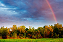 A Late Summer Or Autumn Landscape With Trees, Sky And Rainbow 