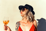 Fototapeta Mapy - Beautiful girl in drinks Aperol Spritz wine from a glass in a restaurant, a cafe, has a good weekend, a stylish fashionable woman, a brunette young, emotional, outdoor close up hipster portrait
