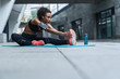 © InsideCreativeHouse - Fitness woman with earphones exercising and stretching outdoors on fitness mat