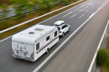 Wall Mural - travel on car with caravan trailer by highway