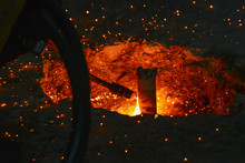 A Gas Cutter In Production, A Welder Removes Unnecessary Metal Residues With A Gas Cutter, Sparks Fly In Different Directions.