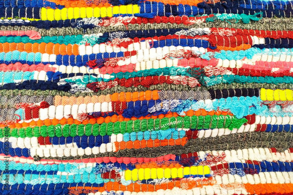 Handmade rug from old used clothes. The carpet is sewn from multi ...