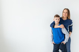 Parenting, family and single parent concept - A happy mother and teen son laughing and embracing on white background with copy space