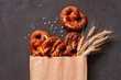 Fresh salted pretzels in the paper bag on the brown table