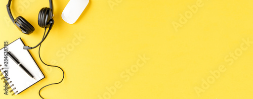 Fotografía Call center desktop with headset and accessories on yellow table