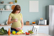 © Pixel-Shot - Beautiful pregnant woman with glass of water in kitchen