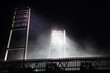 floodlight of the weser stadion at gametime at night with smoke