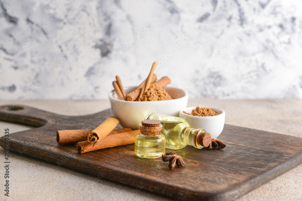 Aromatic cinnamon sticks, powder and essential oil on table