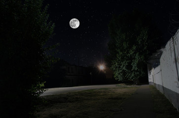 Wall Mural - full moon over quite village at night. beautiful night landscape of old town street with lights. rus