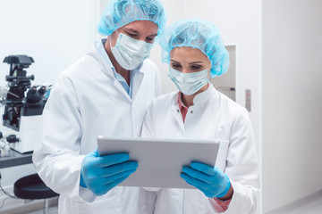 Two scientists working together in lab looking at data