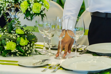 Waiter decorate and setting luxury party dinner table in restaurant.