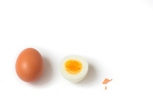Two Eggs In Line (1 Whole Brown Egg And а Half Of A Hard Boiled Egg). Small Piece Of Shell. White Background, Day Light, Space For Text.