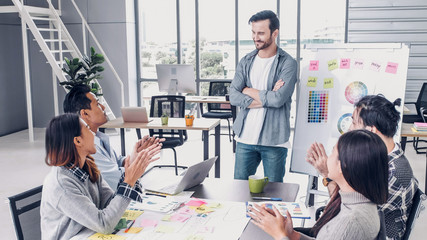 Creative director team lead clap hand with designer team at meeting table.discussion idea in creative office