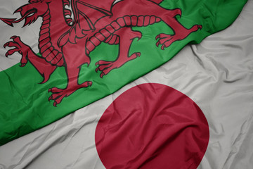 waving colorful flag of japan and national flag of wales.