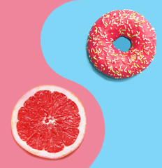 Donut on a blue background and pink grapefruit.