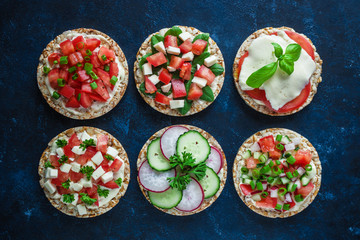 Wall Mural - various healthy sandwiches with rice cake chopped tomatoes radish cucumber basil cheese green onion top view