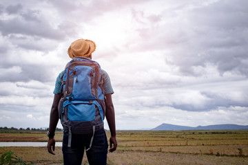 Wall Mural - African tourist  traveler man with backpack on view of mountain background