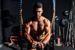 © Srdjan - Young strong focused fit muscular man chest stretching workout in improvised gym with rubber for strength and good looking of muscles dark image