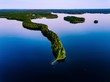 Aerial view of blue lakes with islands and green forests  in Finland.
