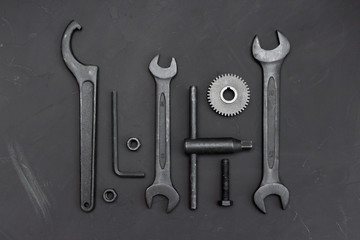 Square layout of different tools on dark background. Wrench tools, gear wheels, ring spanners, monkey wrenches, cogwheel, screws and bolts. Father's Day concept. Do it yourself. Flat lay