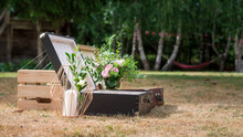 A Couple Of Old Vintage Suitcases On The Ground Decorated With Some Flowers Ad A Candle