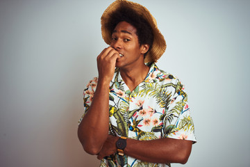 Sticker - Afro american man on vacation wearing summer shirt and hat over isolated white background looking stressed and nervous with hands on mouth biting nails. Anxiety problem.