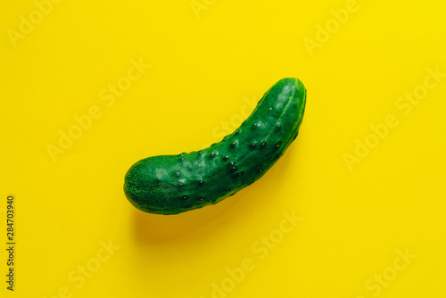 Fotografía One ripe cucumber on yellow background. Flat lay.