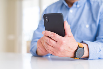 Sticker - Close up of man hands using smartphone over white table