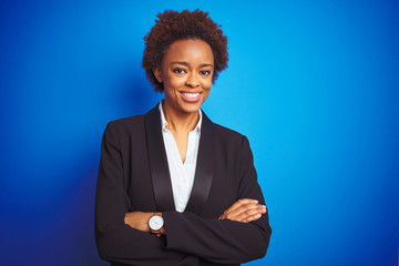 African american business executive woman over isolated blue background happy face smiling with crossed arms looking at the camera. Positive person.