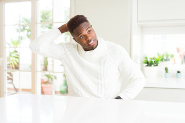 Sticker - Handsome african american man on white table confuse and wonder about question. Uncertain with doubt, thinking with hand on head. Pensive concept.