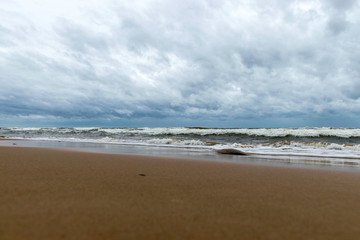 beautiful waves going to the coast, stormy sea with thunder clouds over,