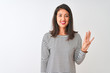 © Krakenimages.com - Young beautiful chinese woman wearing striped t-shirt standing over isolated white background showing and pointing up with fingers number four while smiling confident and happy.
