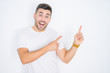 © Krakenimages.com - Young handsome man wearing casual white t-shirt over white isolated background smiling and looking at the camera pointing with two hands and fingers to the side.