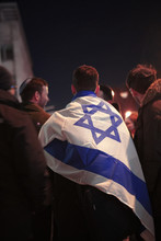 Group Of Young Jewish Men Gathered At Night, With A Flag Of Israel Draped Over One Of Them.