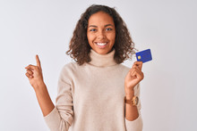 Young Brazilian Woman Holding Credit Card Standing Over Isolated White Background Very Happy Pointing With Hand And Finger To The Side
