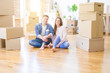 © Krakenimages.com - Young beautiful couple relaxing sitting on the floor around cardboard boxes at home, smiling happy moving to a new house