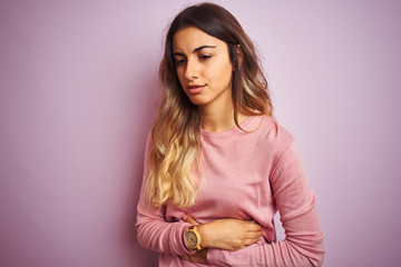 Poster - Young beautiful woman wearing a sweater over pink isolated background with hand on stomach because nausea, painful disease feeling unwell. Ache concept.