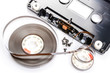 Disassembled audio compact cassette. Audio cassette with tape as security mechanism with cover removed, on white background.