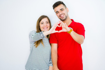 Sticker - Young beautiful couple together over white isolated background smiling in love showing heart symbol and shape with hands. Romantic concept.