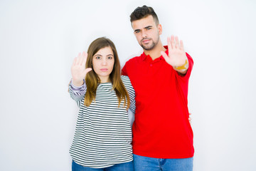 Sticker - Young beautiful couple hugging together over white isolated background with open hand doing stop sign with serious and confident expression, defense gesture