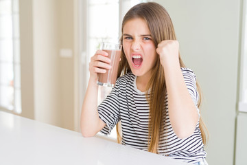 Beautiful young girl kid drinking fresh tasty chocolate milkshake as snack annoyed and frustrated shouting with anger, crazy and yelling with raised hand, anger concept