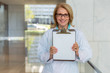 © elnariz - Cheerful smiling medical doctor or dentist at hospital holding up test results, chart, blank template sign