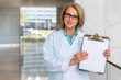 © elnariz - Female doctor physician holding up blank clipboard, white card template, health care and medicine