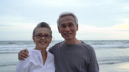 Wall Mural - Asian couple senior elder looking camera closeup sunset beach honeymoon family together happiness people lifestyle, Slow motion footage