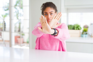 Sticker - Beautiful african american woman with afro hair wearing casual pink sweater Rejection expression crossing arms and palms doing negative sign, angry face