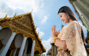 Beautiful Thai woman portrait dress up in traditional thai costume at Temple of the Emerald Buddha or Wat Phra Kaew in Bangkok, Thailand.